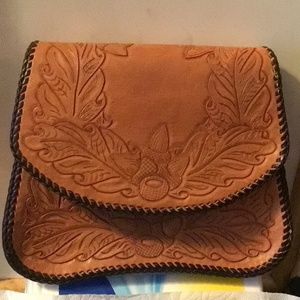 Western Leather hand tooled bag. 3 inside pockets . Brass Latch , leather strap